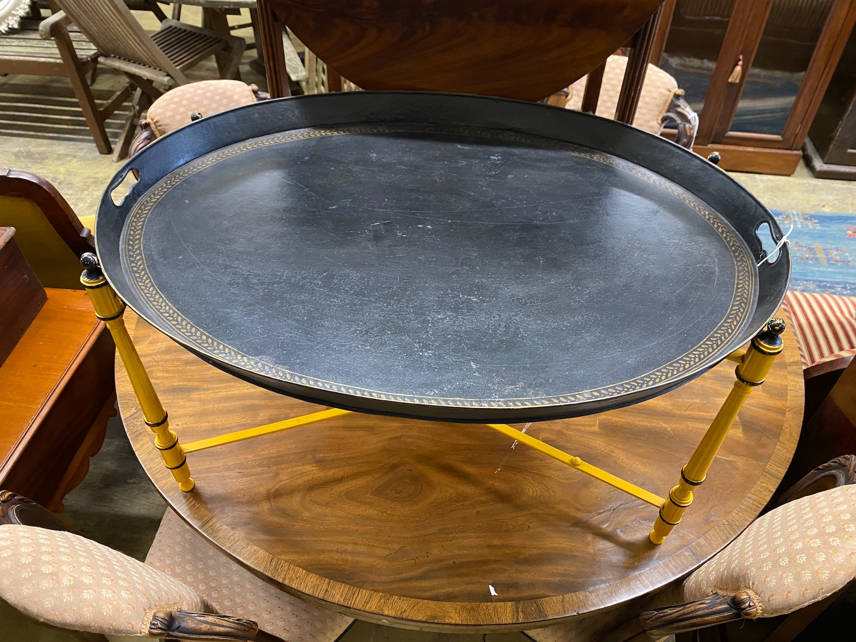 An oval Regency style toleware tray top table on folding stand, width 80cm, depth 61cm, height 43cm